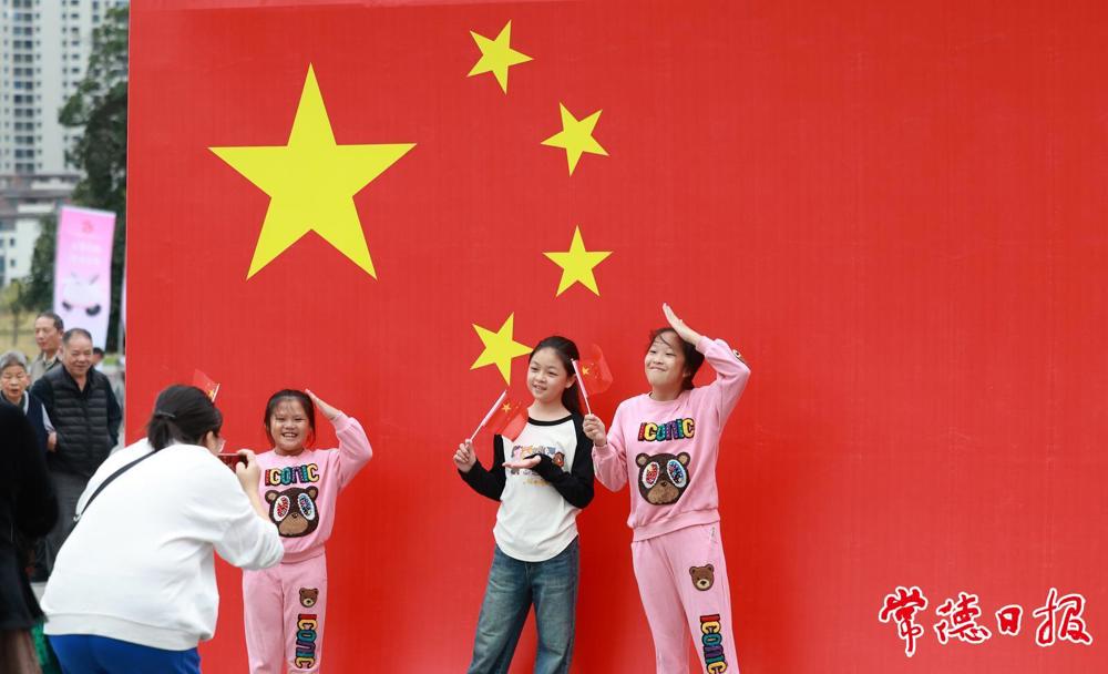 2024年10月1日,小游客们在常德河街与国旗合影 2024年10月1日,小游客们在常德河街与国旗合影